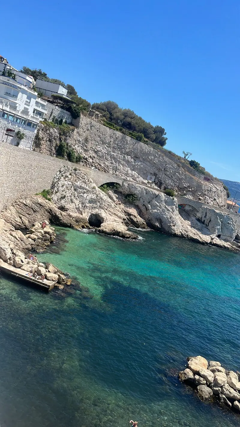 A turquoise cove with clear water below white limestone cliffs on the Marseille coast