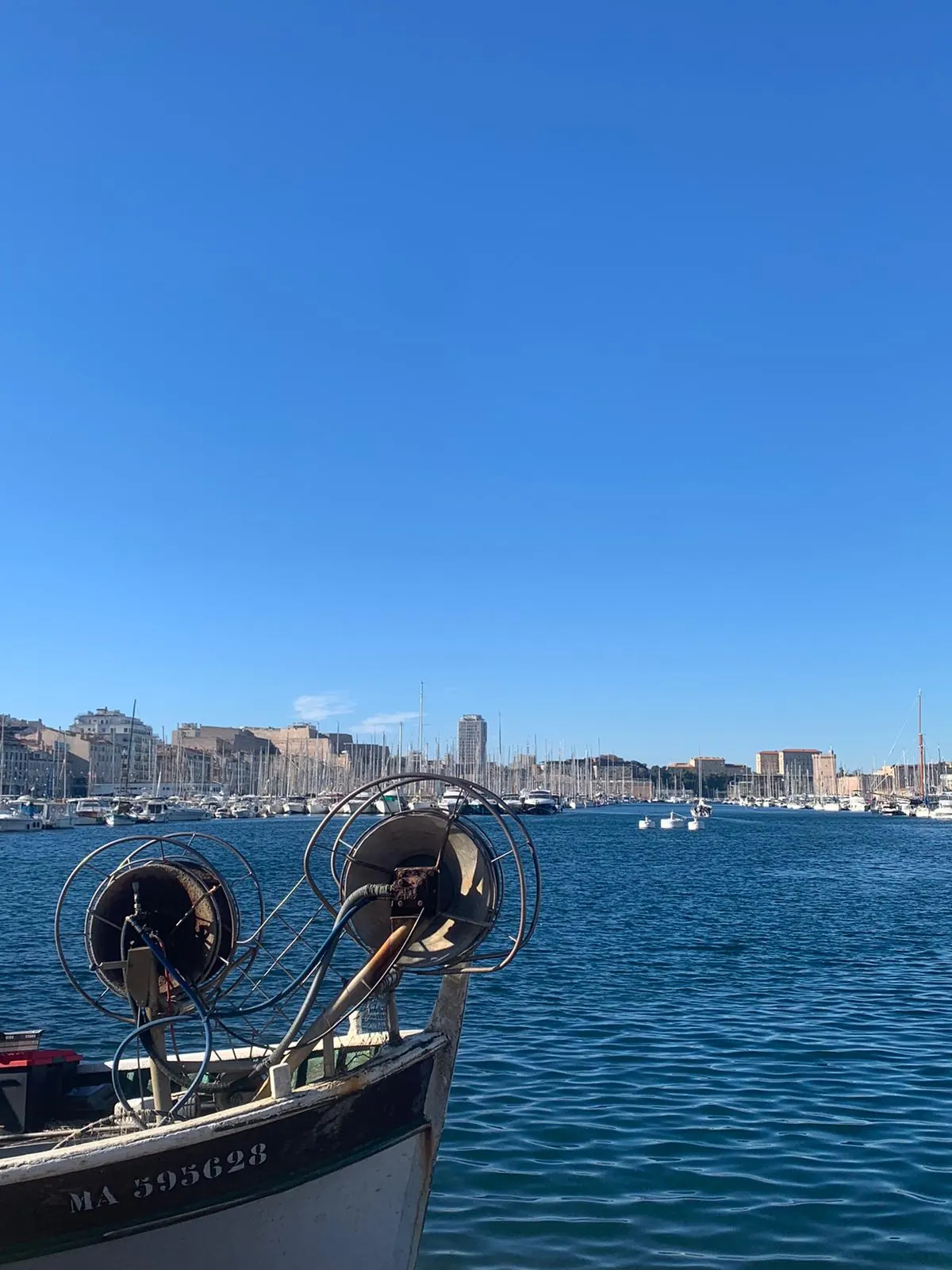 Der Vieux-Port vom Deck eines traditionellen Pointu-Boots, dahinter die Skyline der Stadt